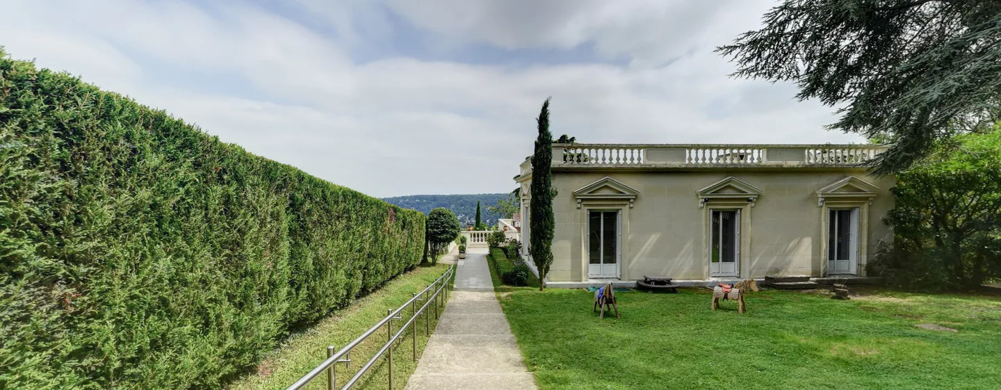 The school building and garden beside a hedge-lined path